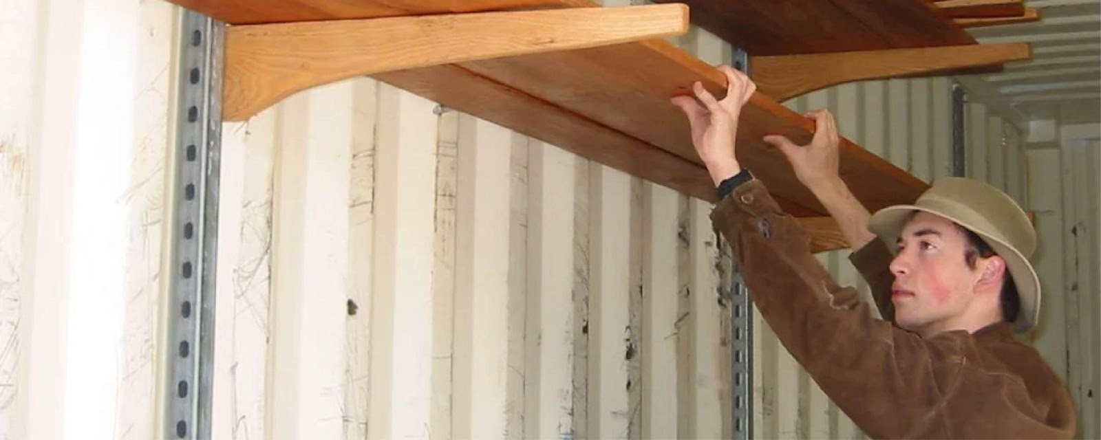A worker installing shelves in a container