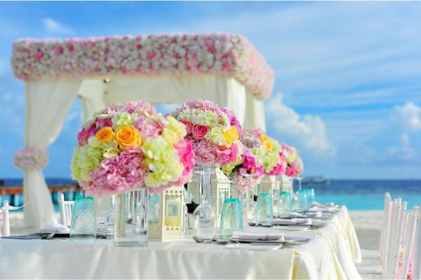Florale Strandhochzeit mit einem mit dekostoffen abgehängtem Pavillion