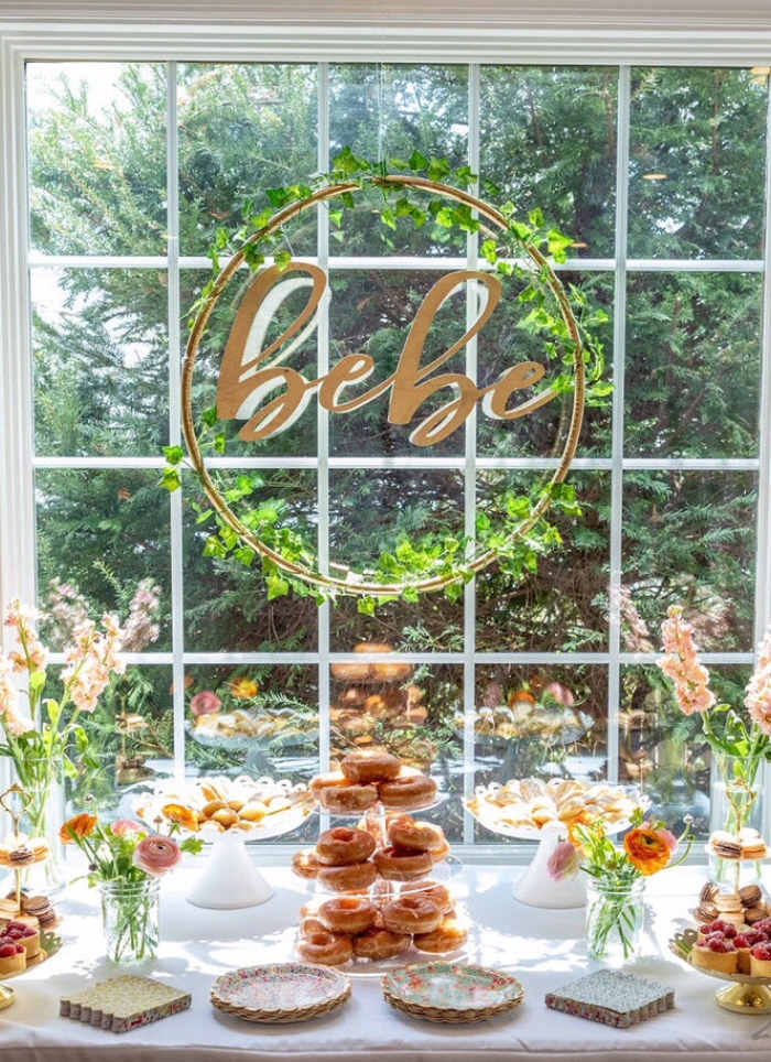 bebe sign hanging over flowers and food on a table
