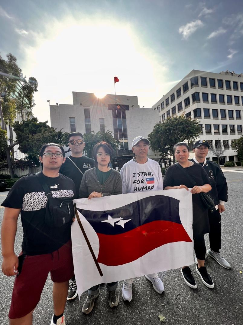 A group of people holding a flag

Description automatically generated