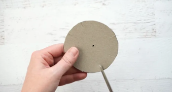 A hand holding a cardboard circle

Description automatically generated