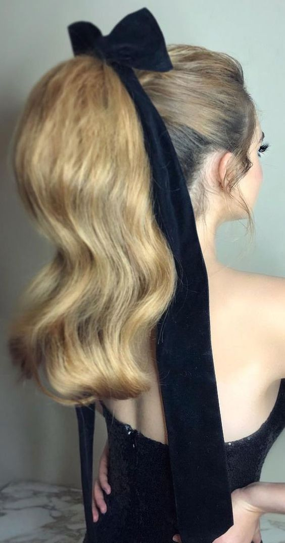 Back view of a lady wearing a  Sleek High Ponytail with a Bow