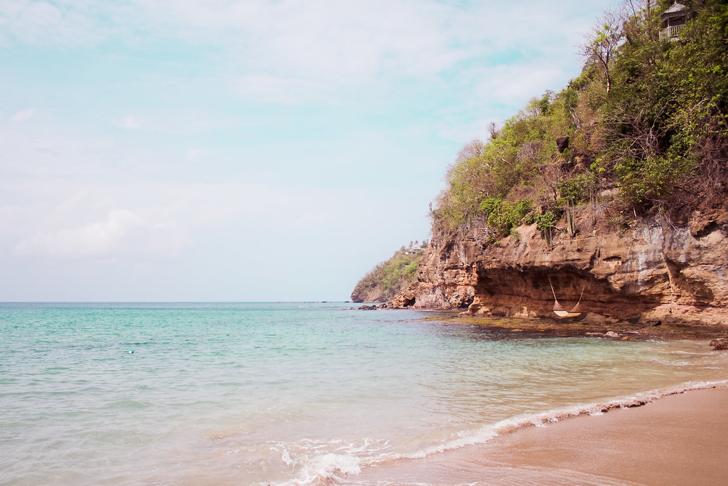 Vibrant blue water beneath a sky tinged with soft pink hues.