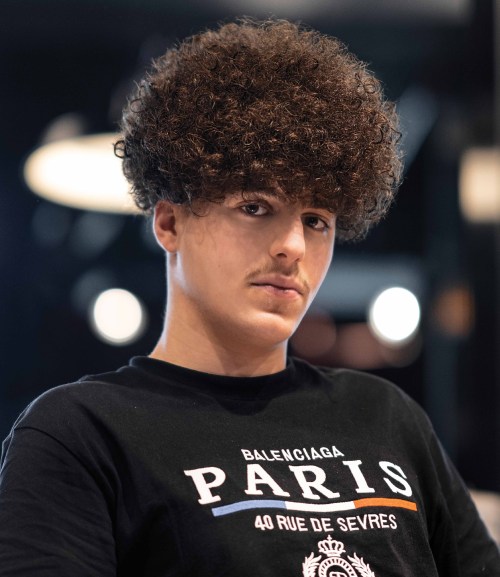 Picture of a guy wearing his Curly Hair  with Two Block Cut Idea