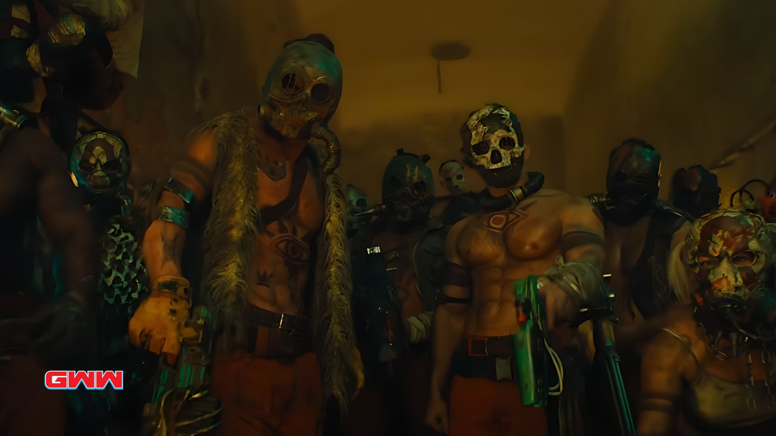 Group of masked, tattooed individuals in a dark, intense setting.