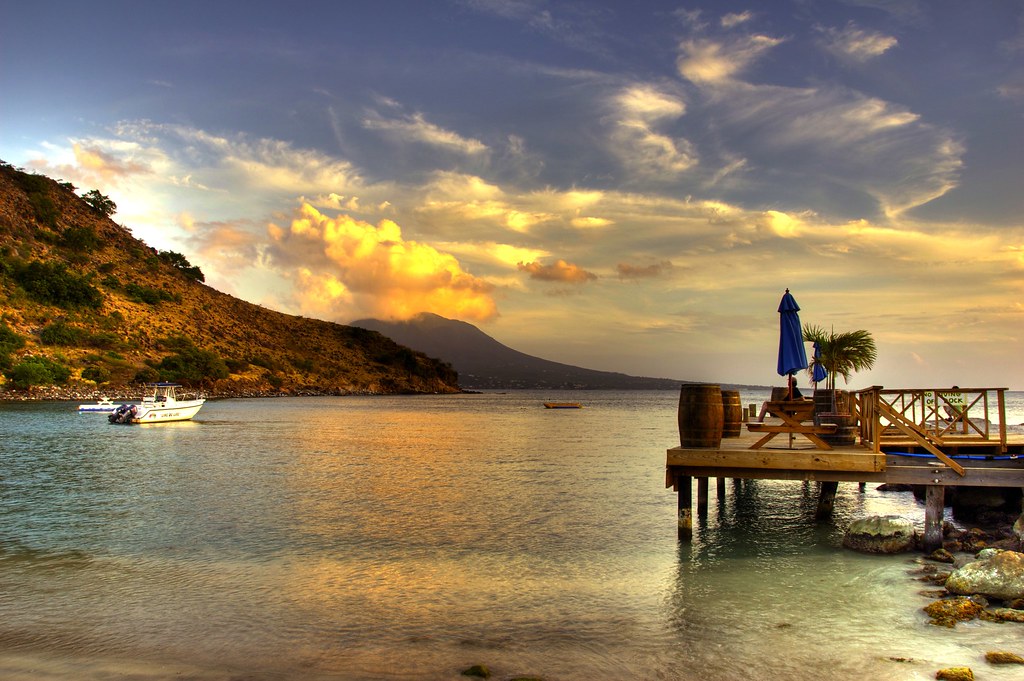 Scenic lake with a boat, mountains in the background, and a dock extending in the corner.