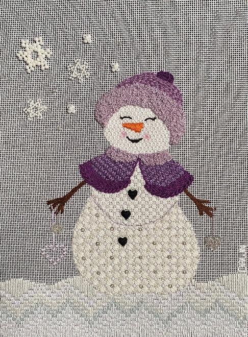 A snowman embroidery on a fabric

Description automatically generated