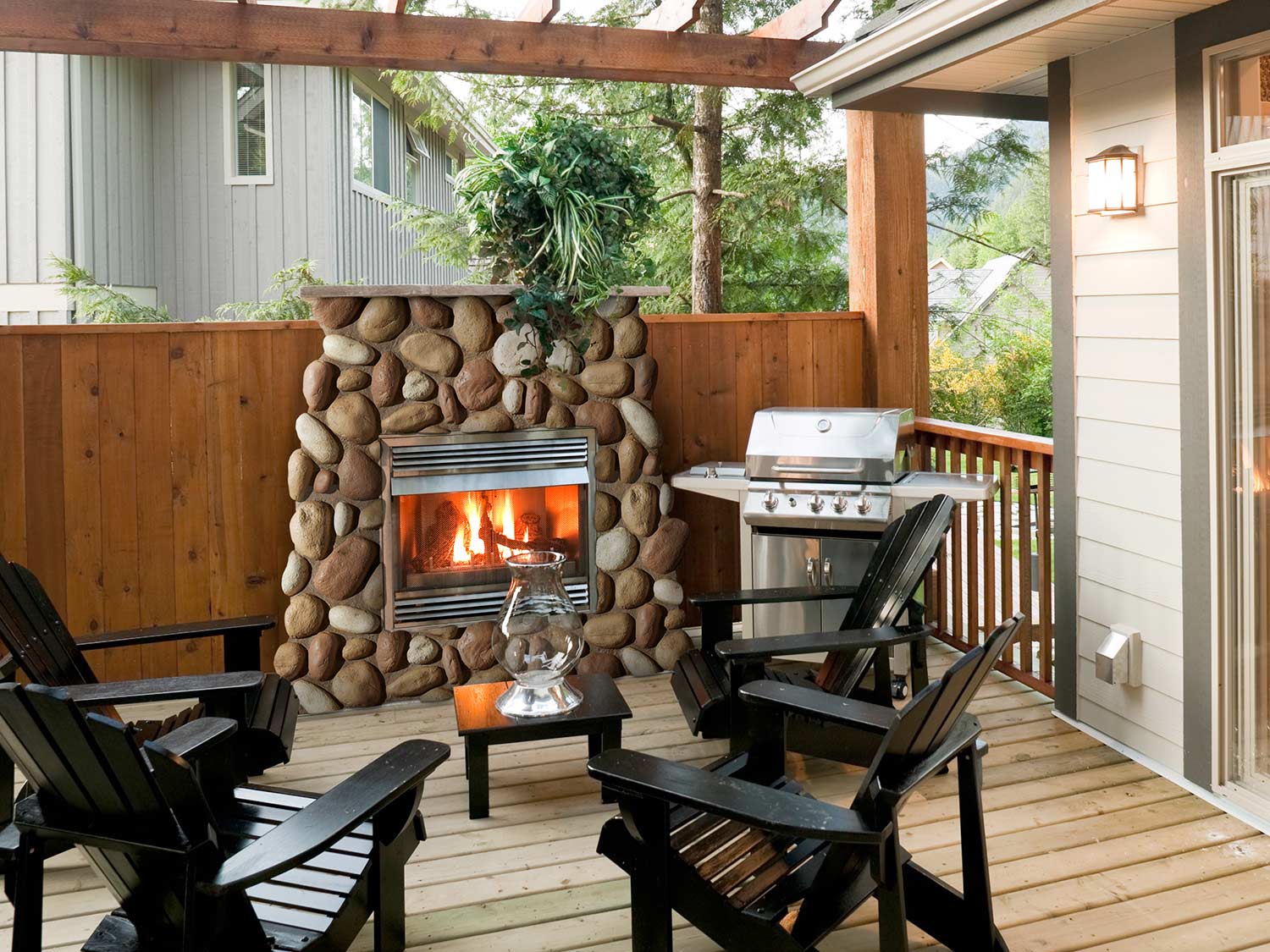 Faux River Rock Wall Panel in Mixed Tan attractively surrounding a back deck fireplace