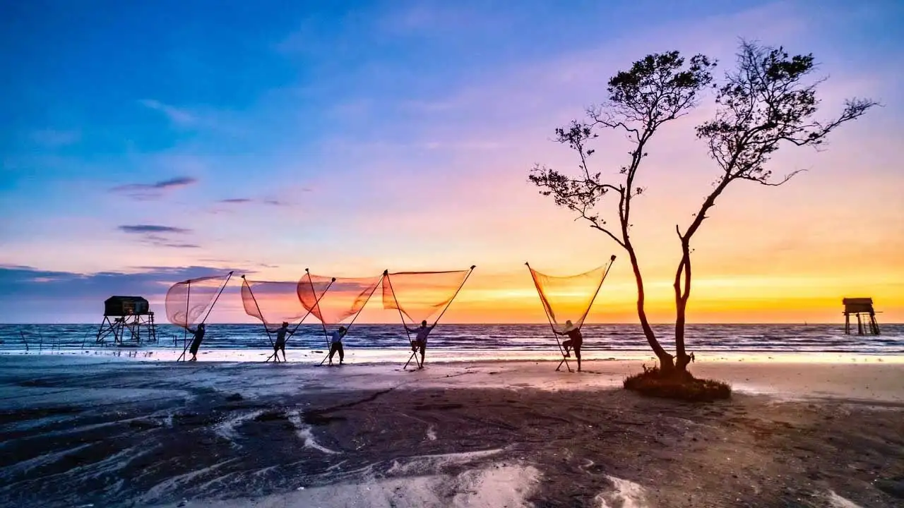 A group of people holding nets on a beach

Description automatically generated