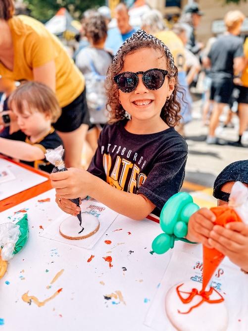 A child with sunglasses and a bag of foodDescription automatically generated with medium confidence