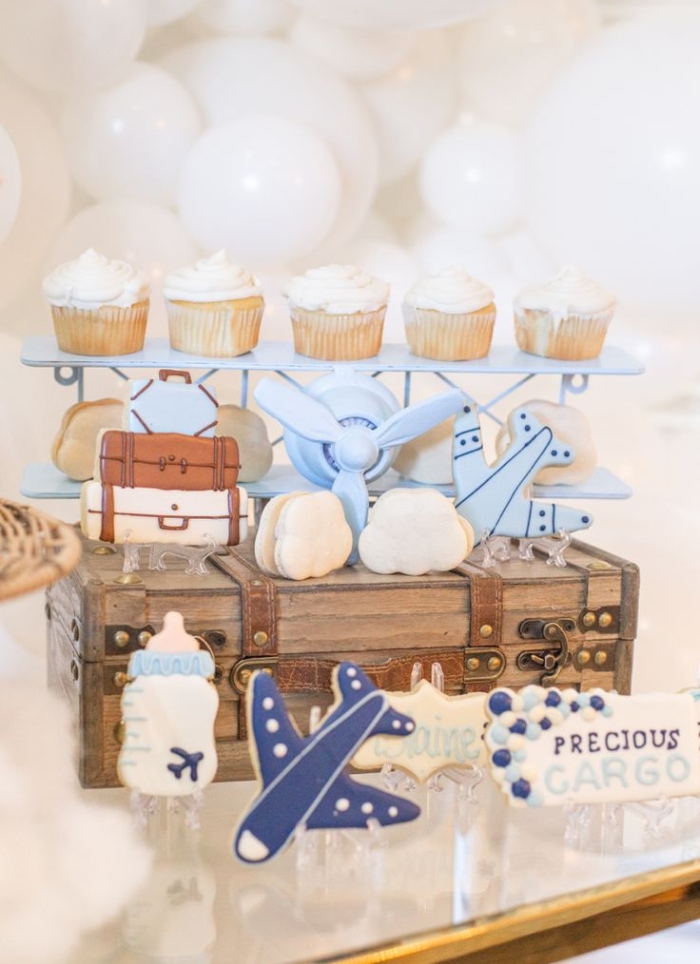 white cupcakes sitting on blue plane wings