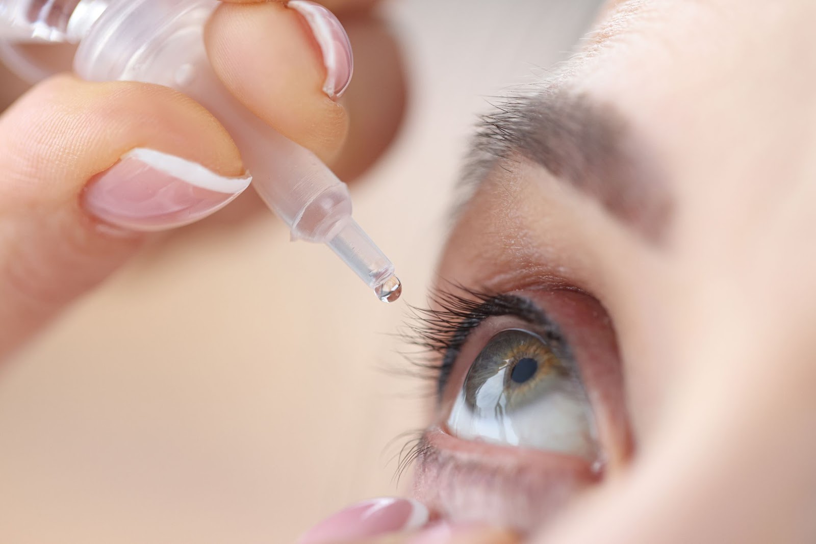 Close-up view of a person putting eye drops into one of their eyes