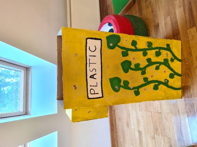 A yellow box with a green plant painted on it

Description automatically generated