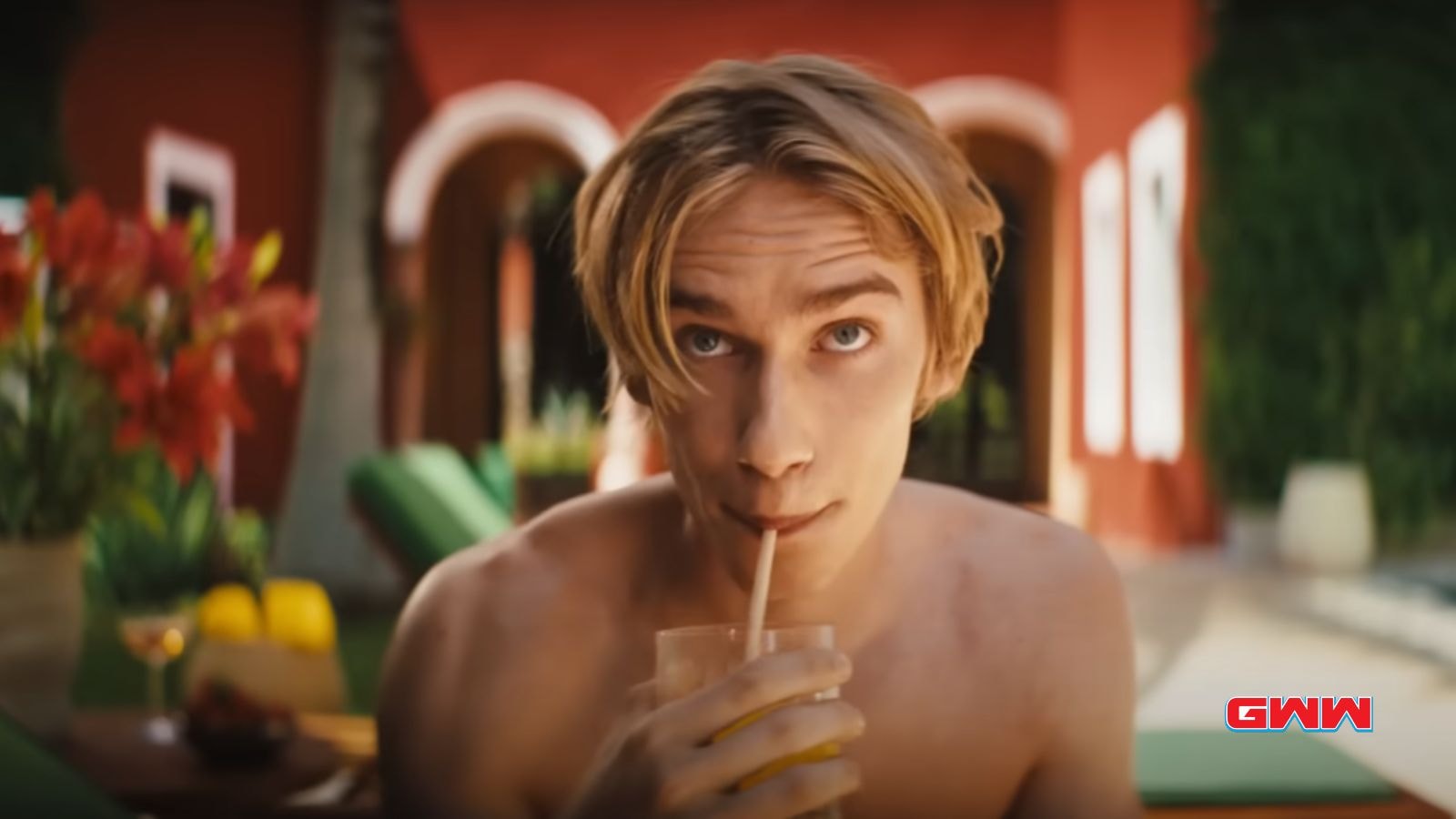 Lucas sipping a drink poolside with a relaxed expression.