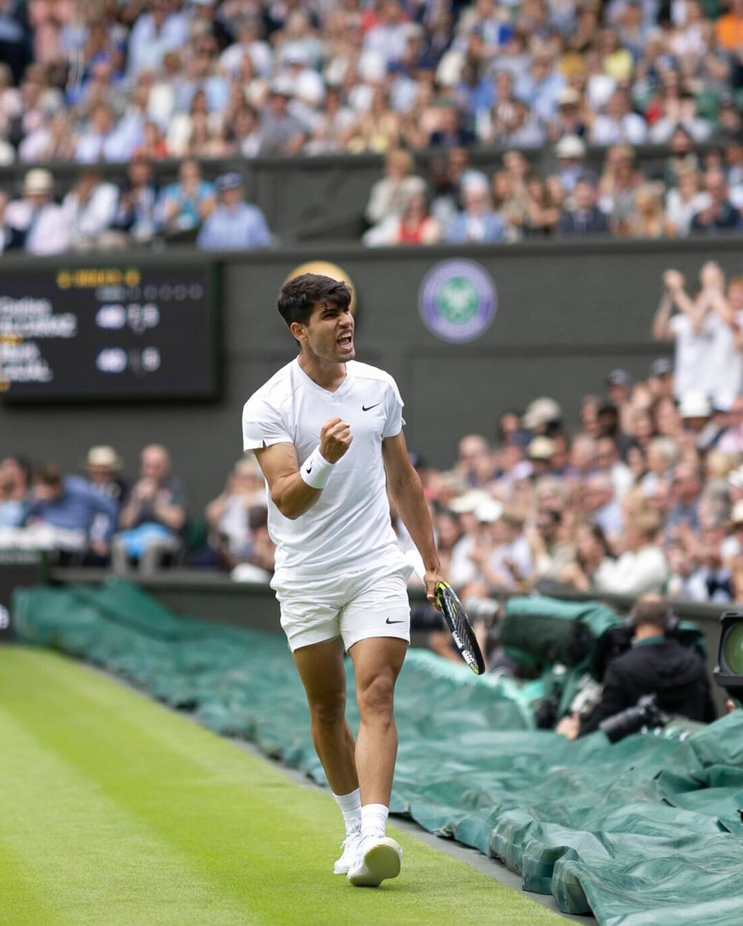 Photo shared by Carlos Alcaraz Garfia on July 01, 2024 tagging @wimbledon. May be an image of 3 people, people playing tennis, stadium and text.