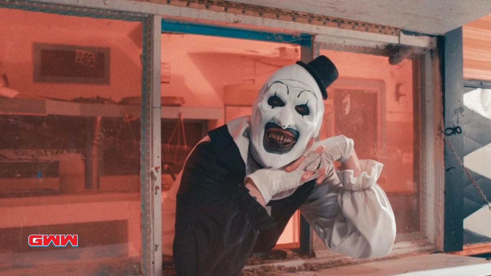 Art the Clown casually smiling with hands folded together, cast of Terrifier 3