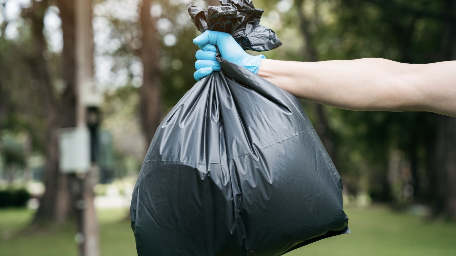 man holding a black trashbag