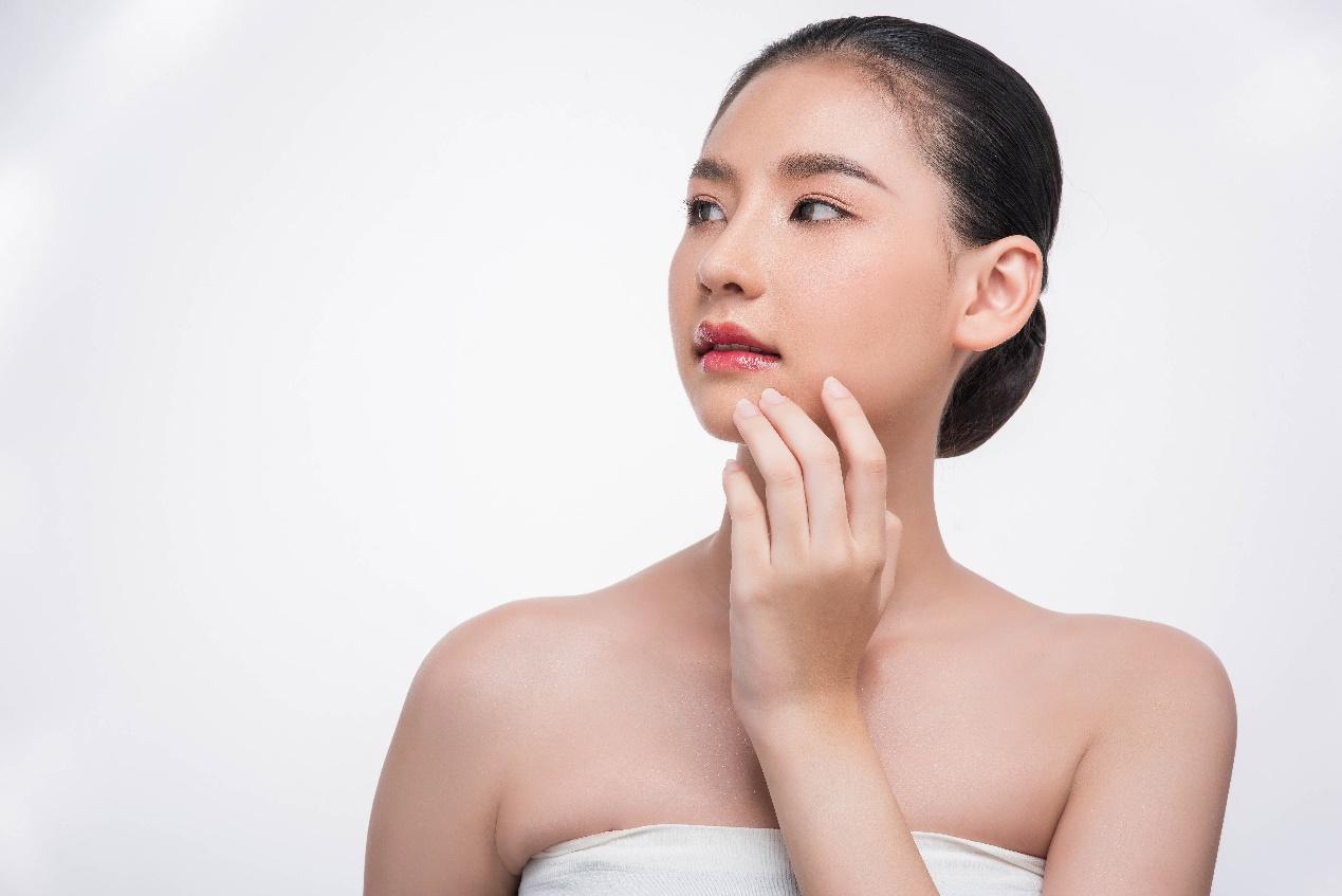 A person touching her face

Description automatically generated