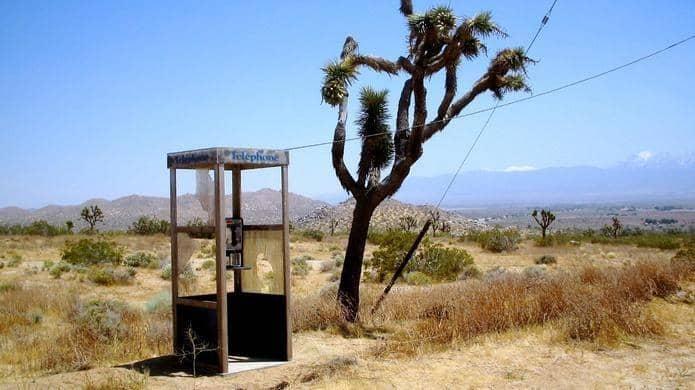 A telephone booth in the desert

Description automatically generated