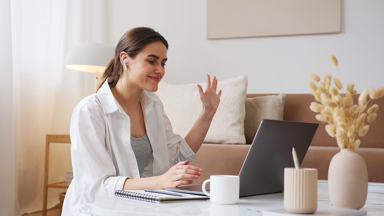 Free Cheerful woman having video call via laptop Stock Photo