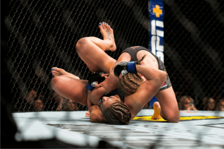 Two UFC fighters wrestling in the ring