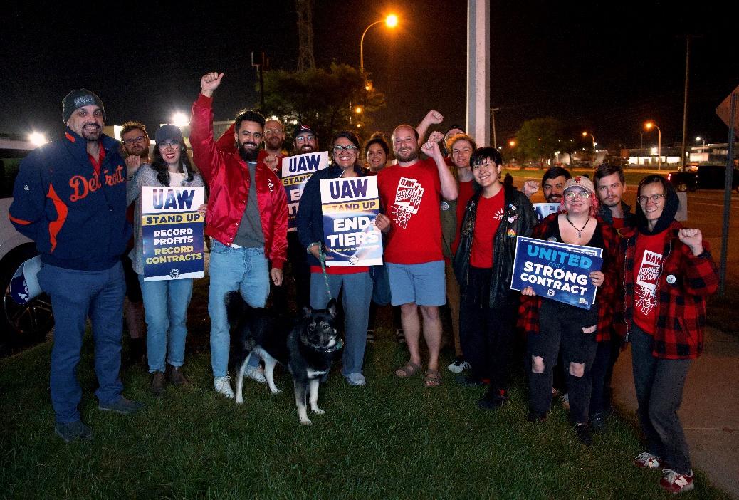 Rashida stands with autoworkers.