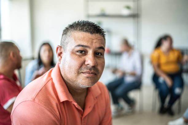 Portrait of mid adult man during a group therapy at mental health center Portrait of mid adult man during a group therapy at mental health center depressed man stock pictures, royalty-free photos & images
