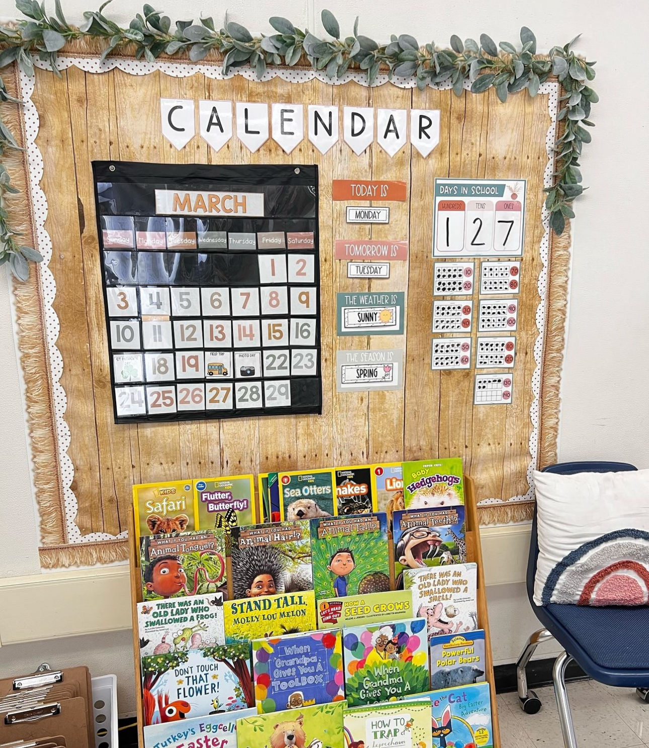 This image shows a calendar bulletin board with greenery hanging from the top of the display. 