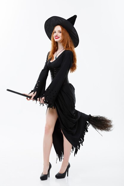 A woman witch holding a broomstick.