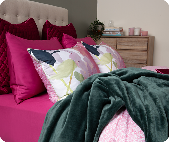 Notre housse de couette Botanical Mambo montrée sous un angle latéral, associée à notre BeechBliss rose drap ensemble  en Azalea.