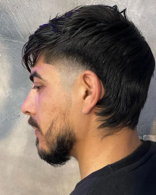 Side picture of a guy rocking the wolfcut for men  with shaved sides