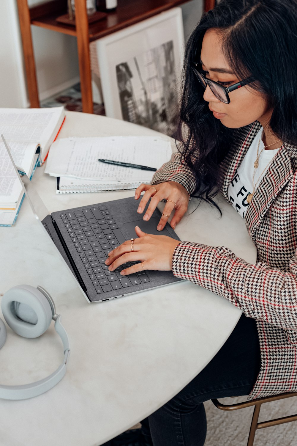 Woman in red and white plaid long sleeve typing on a microsoft laptop - When & How to Ask for a Raise: 7 Tips
