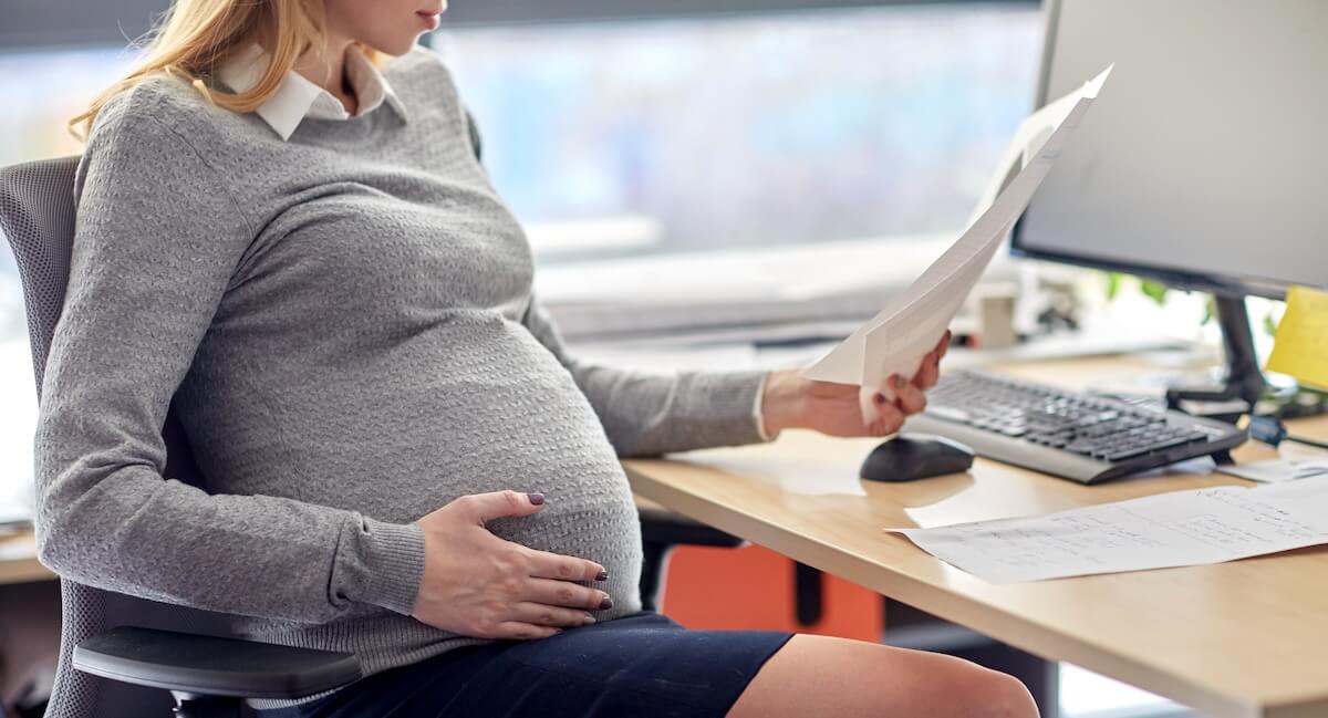 Pregnancy accommodations at work: pregnant employee reading some documents
