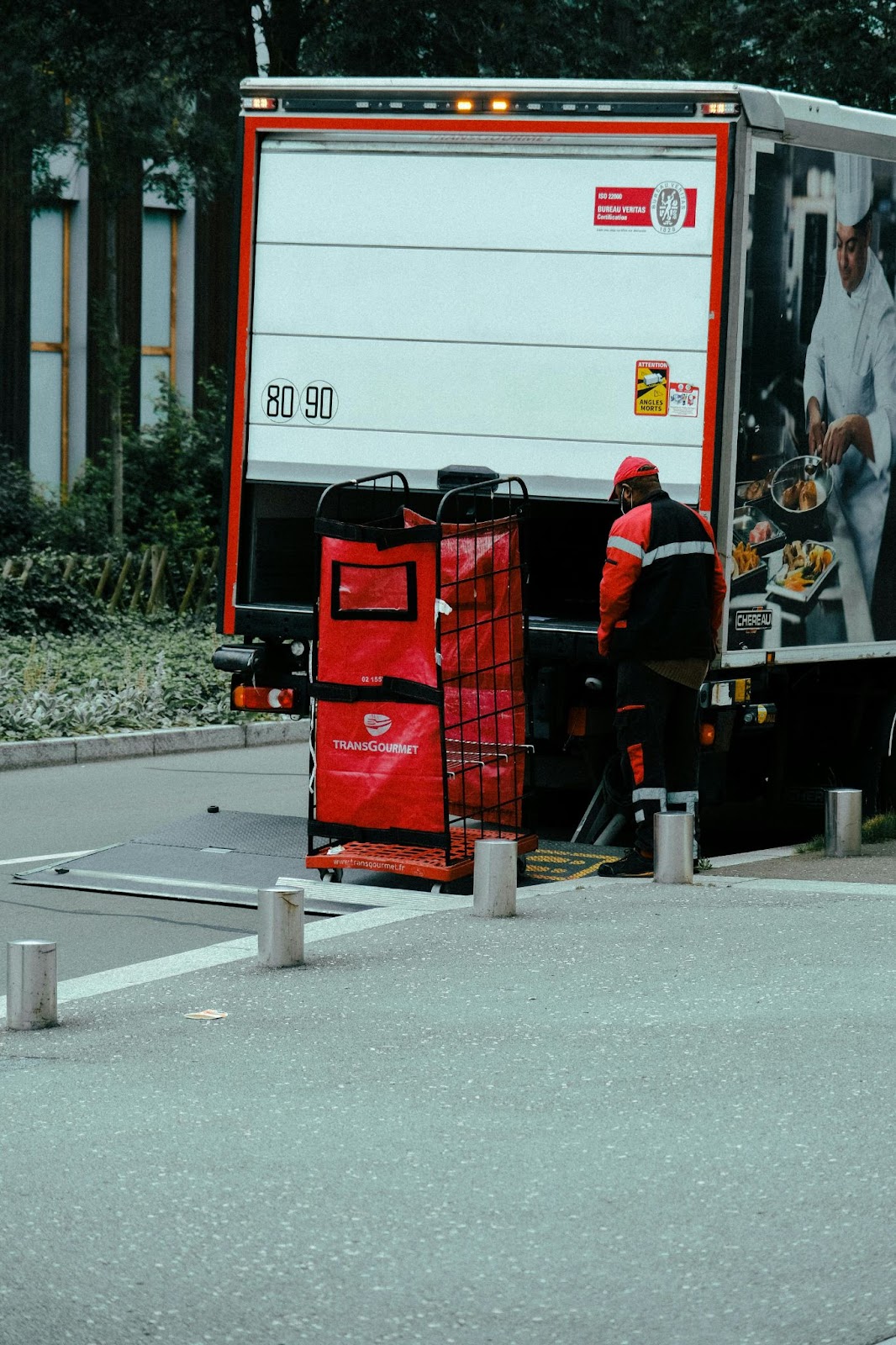 A box truck lowering red catering items