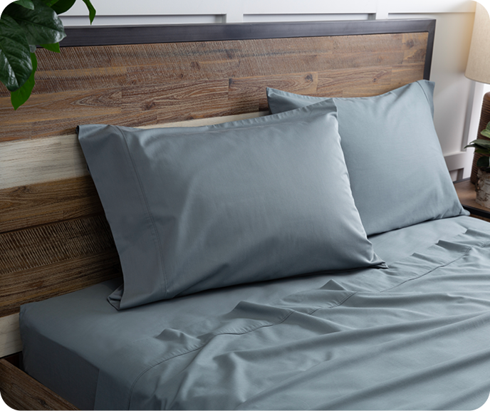 Our blue-grey Bamboo Cotton Sheet Set in Spruce shown on a bed.