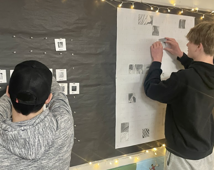 image of students putting up their artwork on the wall