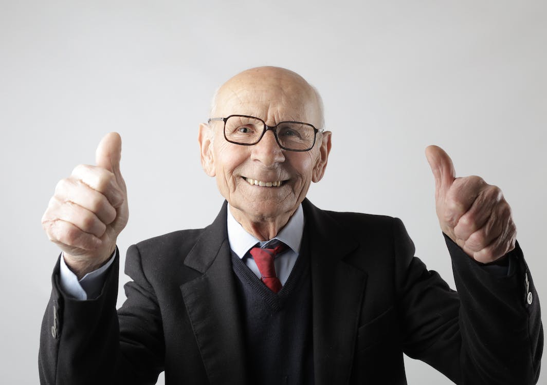 Kostenlos Positiver älterer Mann In Der Brille, Die Daumen Oben Zeigt Und Kamera Betrachtet Stock-Foto