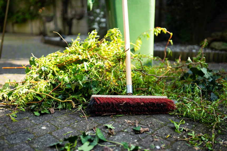 Broom sweeping away debris on concrete.