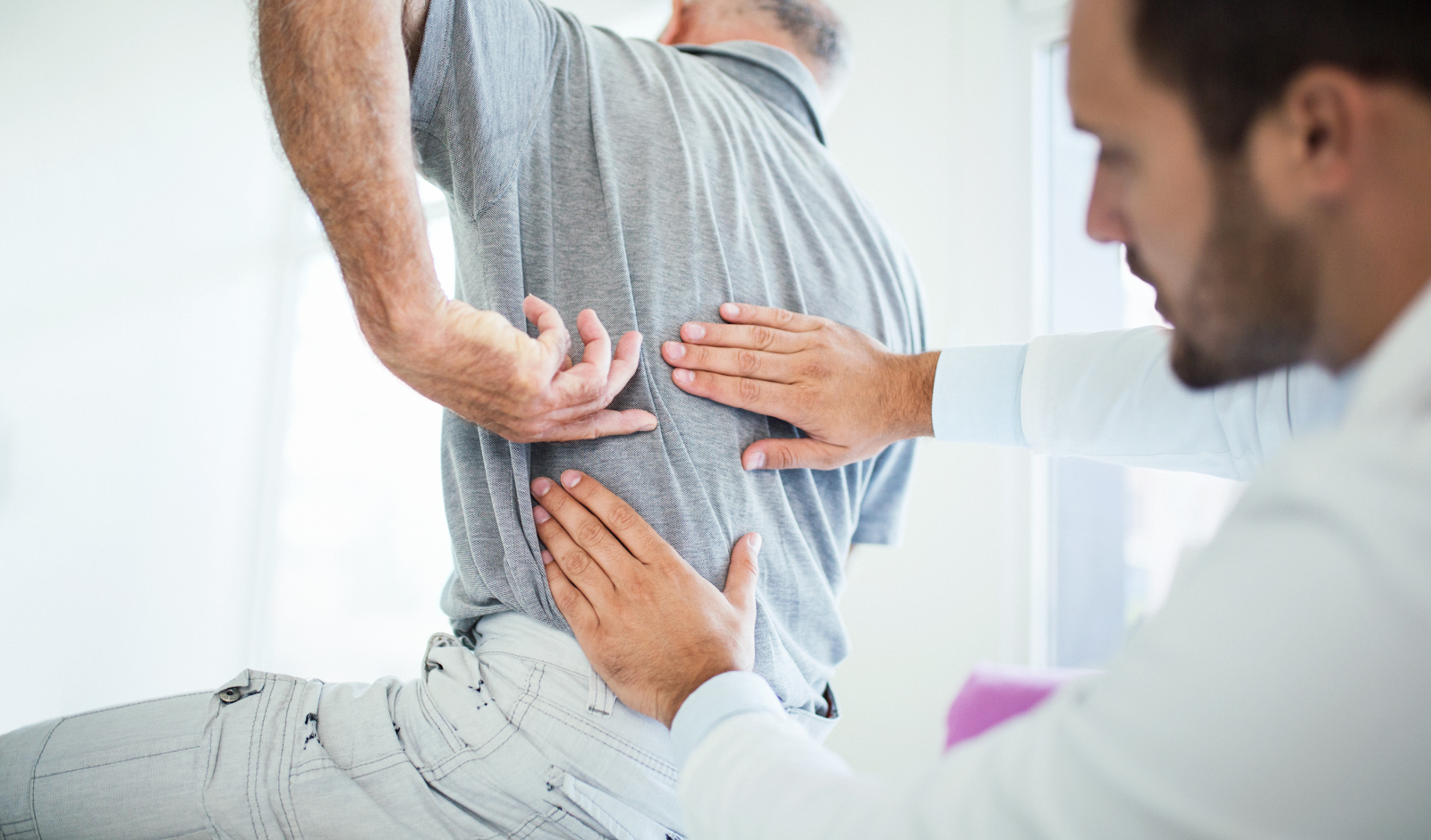 man with a spine injury getting help from a doctor