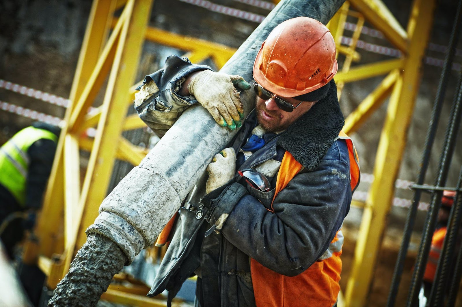 an industrial worker lifting a pipe
