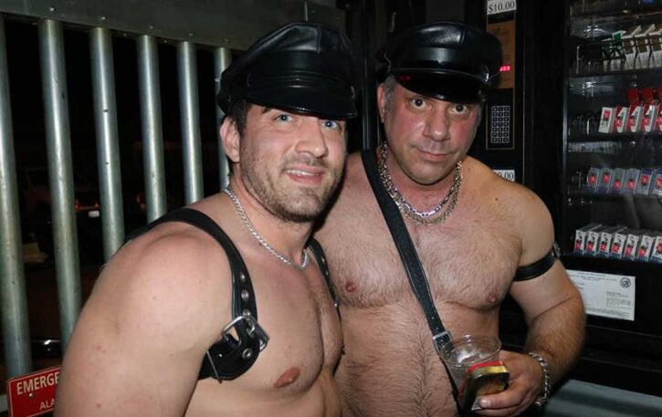 two gay males wearing leather gear and smiling for a photo at the gay leather bar the tool shed located in Palm Springs