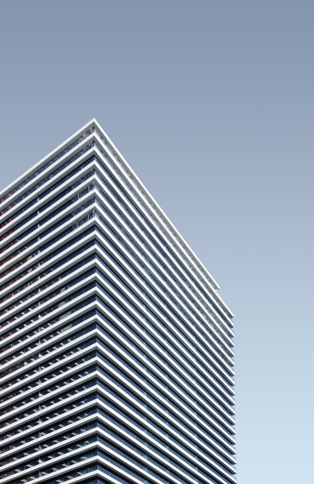 A skyscraper with a louvered facade with a clear blue sky background designed using parametric design principles
