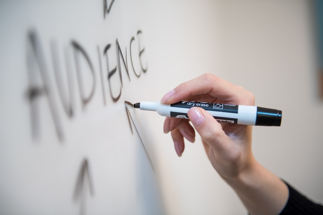 Person holding white and blue click pen.