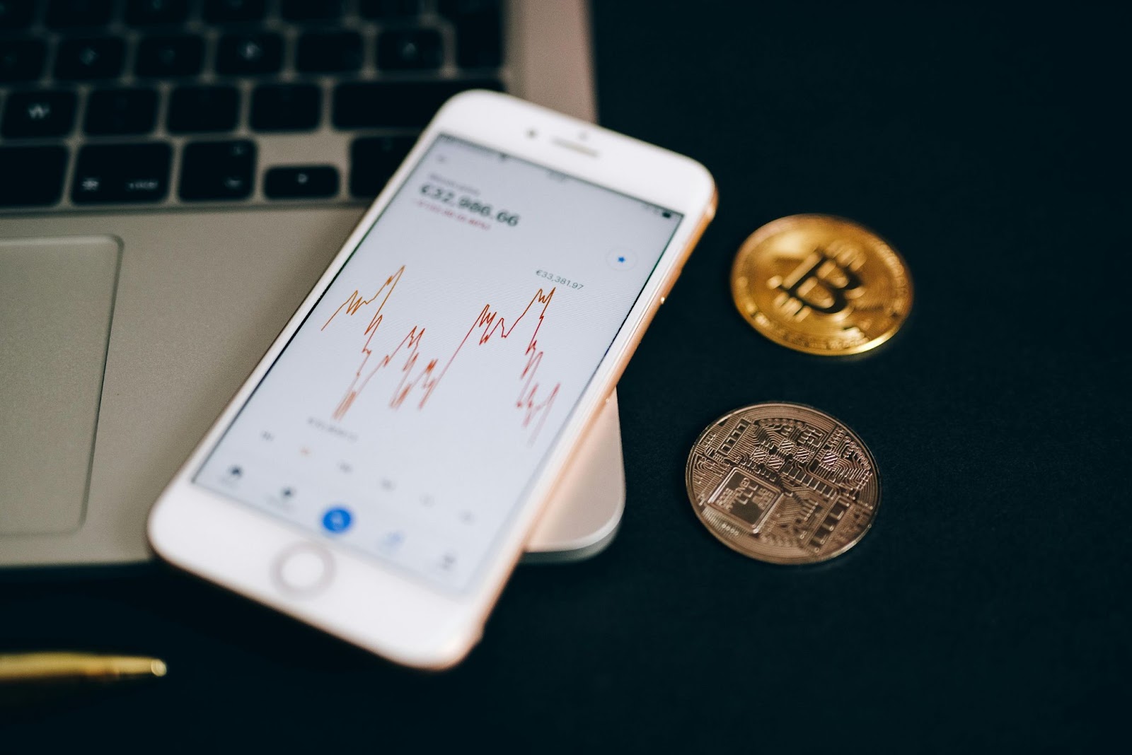 A smartphone on a notebook and there are also some crypto coins