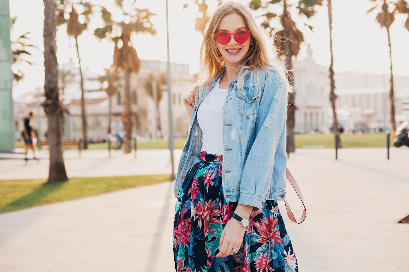 garota posando para a foto ao ar livre usando saia floral combinada com casaco jeans