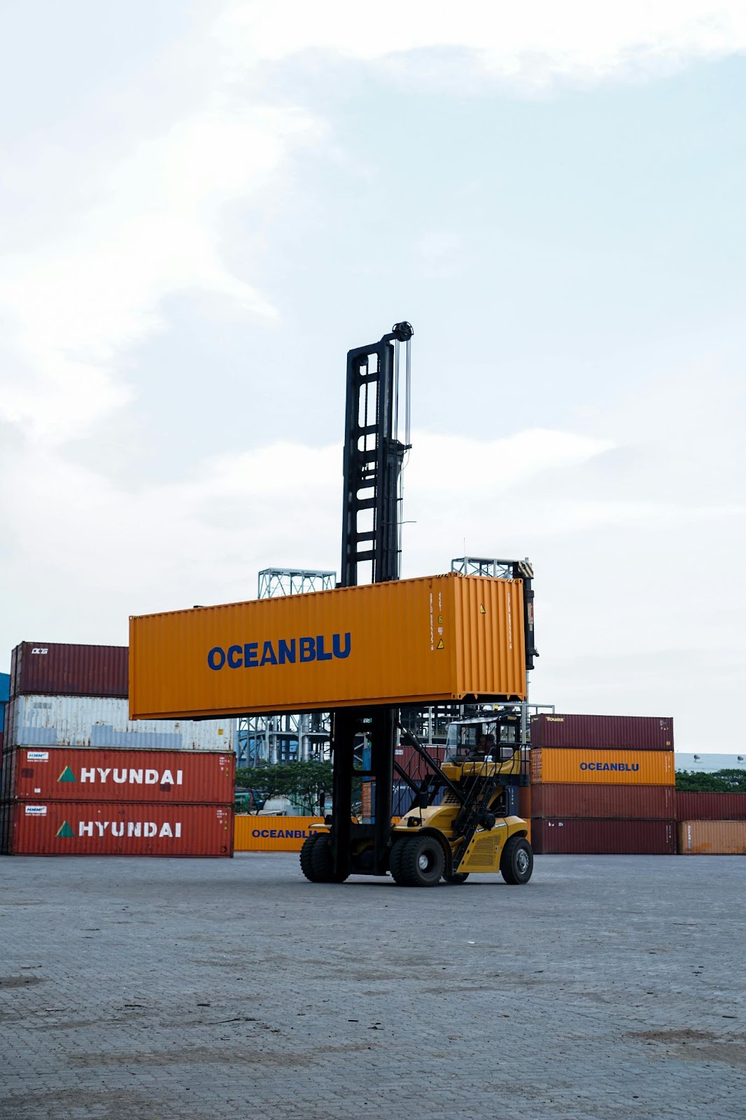 An industrial-sized forklift carrying a freight shipping crate