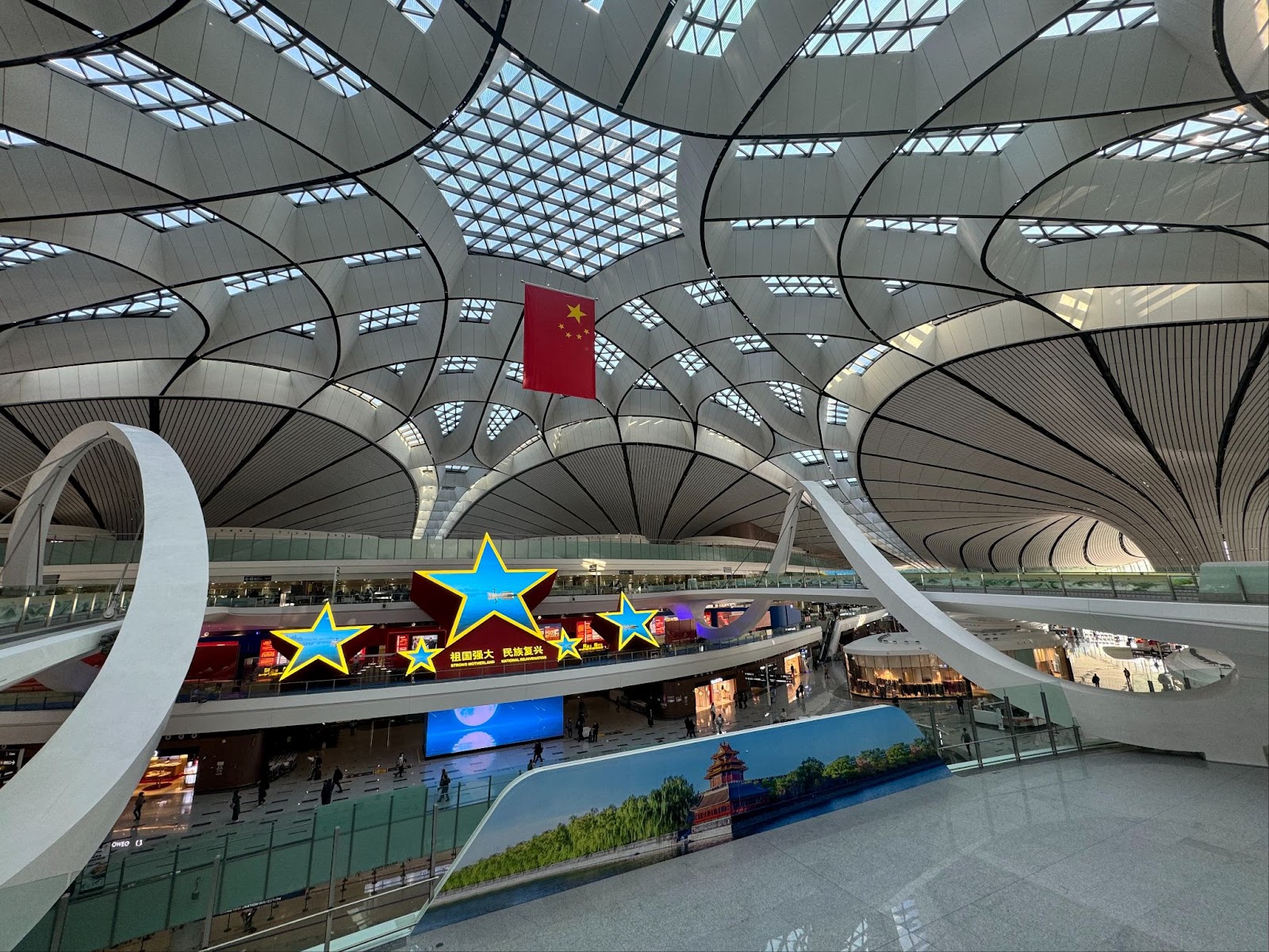 The spectacular architecture inside Beijing Daxing Airport with the Chinese flag in the background