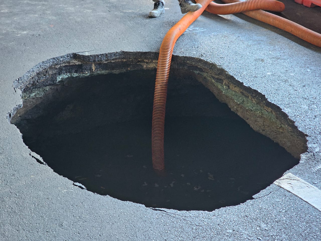 Sinkhole spotted along Sales Road near the Villamor Air Base in Pasay City on Sunday afternoon, April 14, 2024. (INQUIRER.net/ Ram Nabong)