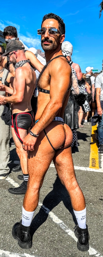 Ali Rush posing outside in the folsom street fair showing off his hairy ass in aussiebum jockstrap while looking over his shoulder