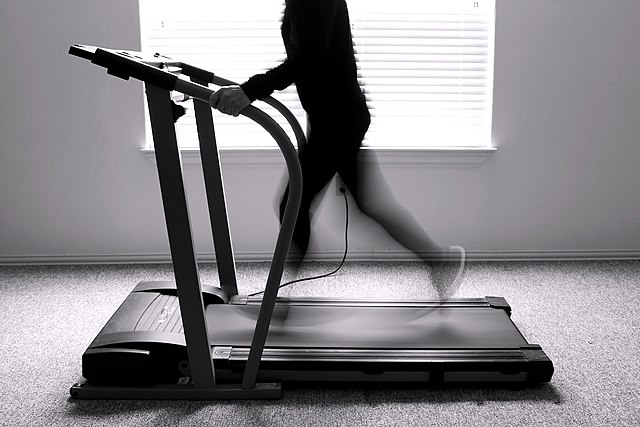 Black and white image of a figure running on a treadmill
